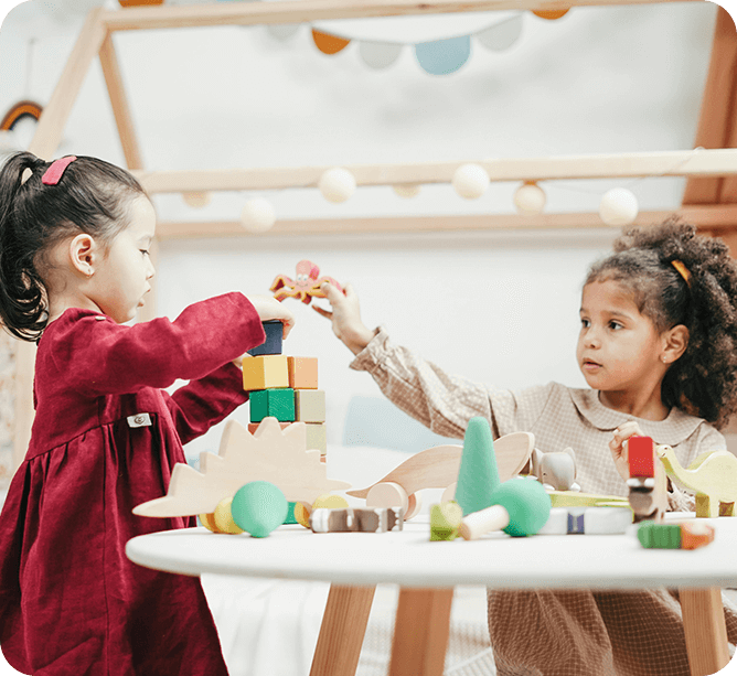 Two girls playing with colorful wooden blocks.