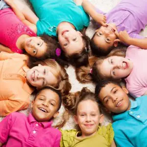 Eight children smiling in a circle.