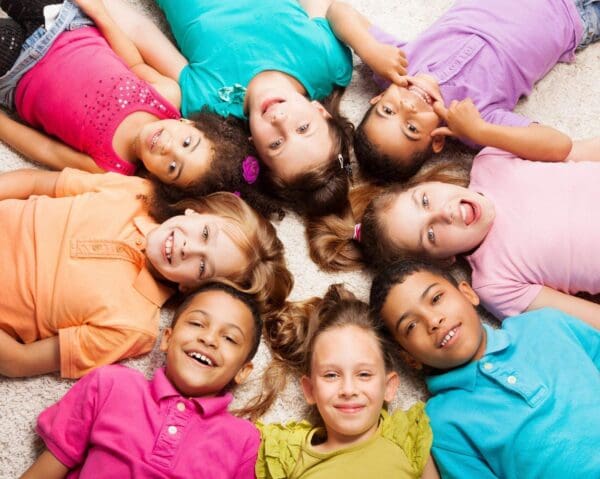 Eight children smiling in a circle.