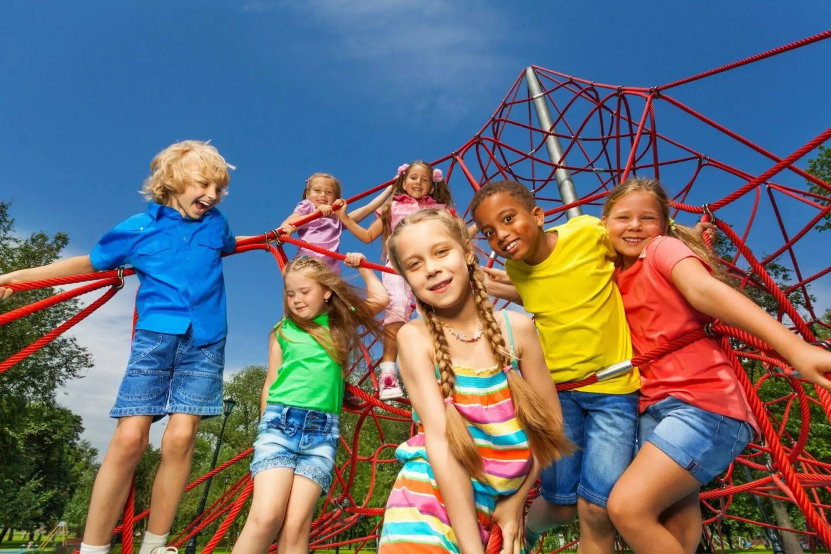 Children playing on a red rope climbing frame.