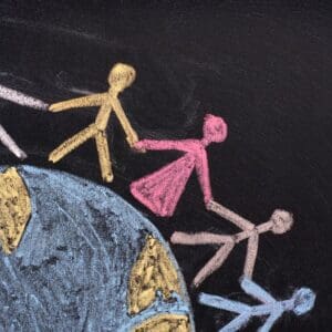 Chalk drawing of people holding hands around Earth.