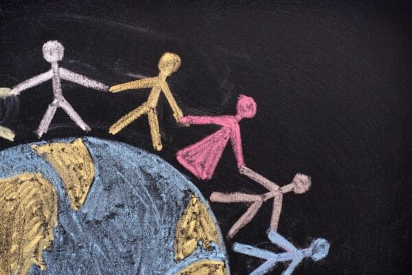 Chalk drawing of people holding hands around Earth.